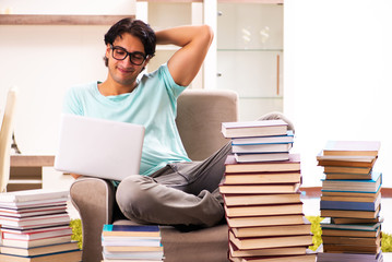 Male student with many books at home 