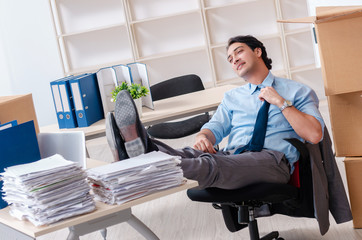 Young man employee with boxes in the office 