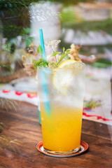 Summer drink; fresh citrus and lime with honey juice on ice in glass; shot through window glass.