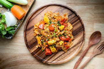 farfalle pasta in tomato sauce with chicken and pork on wooden plate