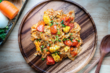 farfalle pasta in tomato sauce with chicken and pork on wooden plate