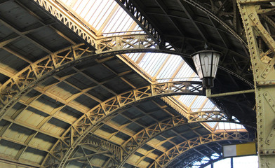 Fototapeta premium Arched glass rooftop of railway station with old vintage lantern, close up view