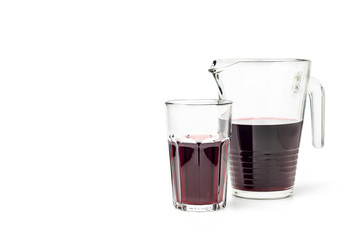 Pomegranate juice in a decanter and a glass on a white background