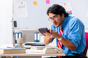 Fototapeta premium Young male financial manager working in the office 