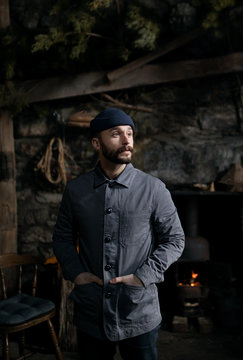 Bearded man in a stone cabin
