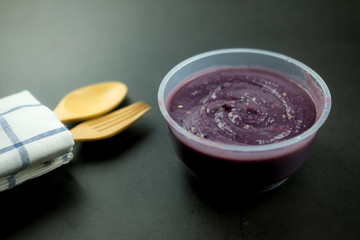 Tasty homemade puree purple potato cream soup put on a black background