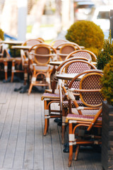 Empty small terrace with plants and wooden floor and furniture.