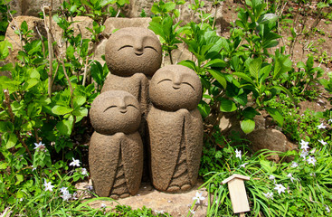Stone statue of three smiling Jizo (Nagomi Jizo), Hasedera temple, Kamakura, Japan