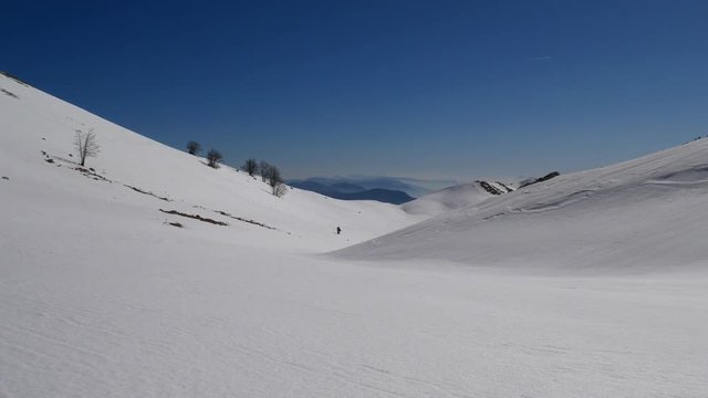 Matese Lake, Campania, Italy - february 2 2019: snowshoeing on snow covered plateau with blue sky. Matese Mounts landscape, Campo dell'esule (Field of the exile), Campo dell'arco (field of the arch)