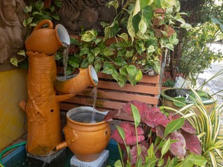 fountain and green plants in flower pots