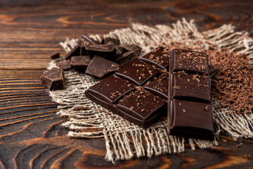 Chocolate bar on dark wooden background.
