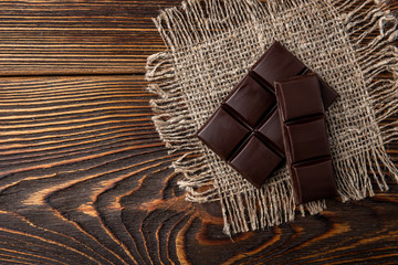 Chocolate bar on dark wooden background.