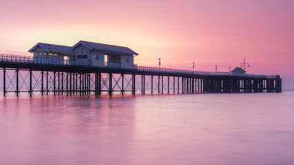 Penarth Pier, on the south Wales coast, near Cardiff, at sunrise. The sky is red and orange, and the sea is smooth