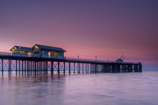 Penarth Pier, on the south Wales coast, near Cardiff, at sunrise. The sky is red and orange, and the sea is smooth