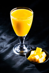 mango juice in glass on black background