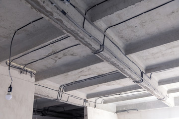 Cable laying ceiling. Electrical wires on wall. Wiring replacement. Connecting light in flat or office. Professional installation bulb, electrical outlets, cables, wires, switches. Insulation