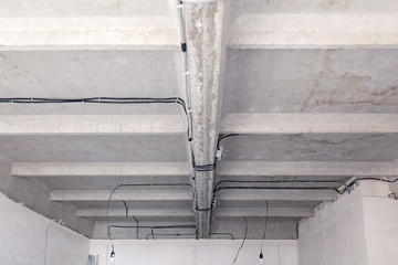 Cable laying ceiling. Electrical wires on wall. Wiring replacement. Connecting light in flat or office. Professional installation bulb, electrical outlets, cables, wires, switches. Insulation