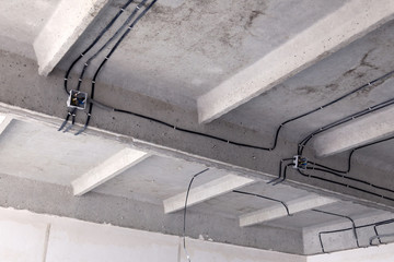 Cable laying ceiling. Electrical wires on wall. Wiring replacement. Connecting light in flat or office. Professional installation bulb, electrical outlets, cables, wires, switches. Insulation