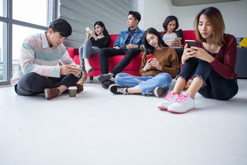 A lonely one man in Group of asian students using smartphone checking social networks online ....