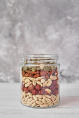 Different types of nuts and seeds in a glass jar close up