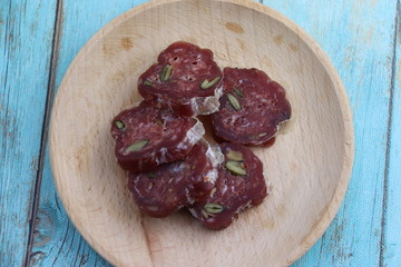 Tranches de saucissons sur une assiette en bois
