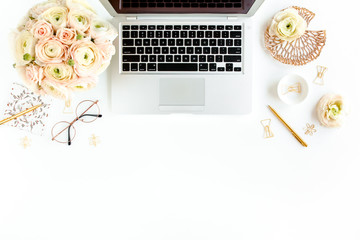 Stylized women's home office desk. Workspace with laptop, computer, bouquet ranunculus and roses, clipboard, feminine golden fashion accessories isolated on white background. Flat lay. Top view.