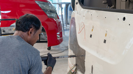 Car body work after the accident by preparing automobile for painting during repair