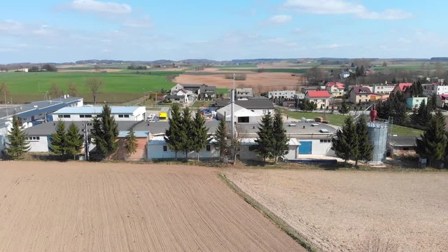 Aerial shot of a carpentry workshop located among cultivated fields and small town, Aerial shot of a small factory located among cultivated fields and small country town