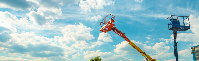 Cherry pickers on blue sky background © scaliger