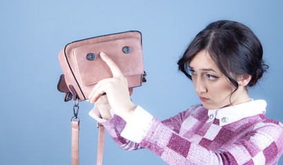 young woman looking for money on the bag