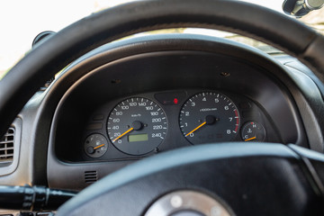 Old Japanese made sports car dashboard with odometer and speed gauges.