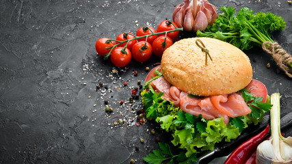 Burger with salmon, tomatoes and onions. Breakfast. Top view. Free space for your text.