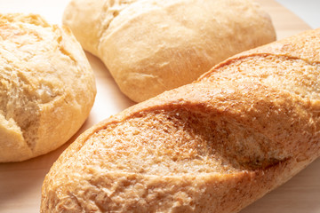 Assortment, different kind of wheat baked bread with golden crust on the table