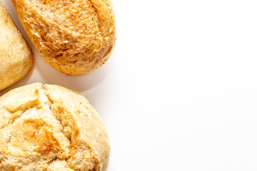 Assortment, different kinds of wheat baked bread with golden crust on white background with copy space, bakery and grocery concept