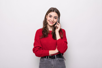 Young woman wear in red sweater talking on mobile phone isolated on a grey background