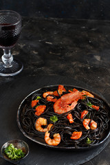 Squid ink pasta with prawns and tomatoes