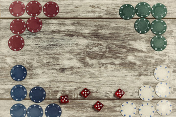 Casino playing chips and dice on a light wooden background are laid out on the edges with the ability to make an inscription in the center