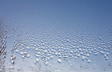 Water drops on the wet window glass. Abstract background. Blue color.