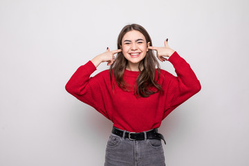 Portrait of young woman in light clothes pointing index fingers on blowing cheeks isolated on white wall background.