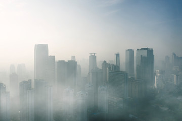Fototapeta na wymiar Modern high buildings covered by fog