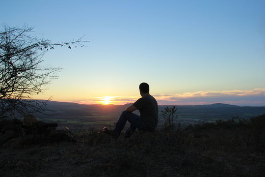 HOMBRE CONTEMPLANDO EL ATARDECER CON NOSTALGIA