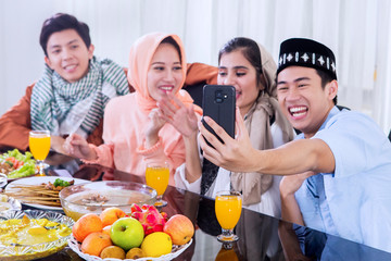 Muslim women and men take photo before eating