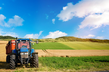 tracteur et sa remorque dans les champs