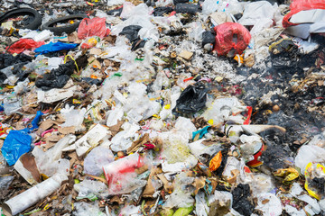 Stack of burnt plastic garbage at the landfill