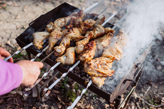 Closeup photo of barbecue grill with chicken meat on outdoor in the summer time. Man cooking food in nature. Concept adventure active vacations outdoor