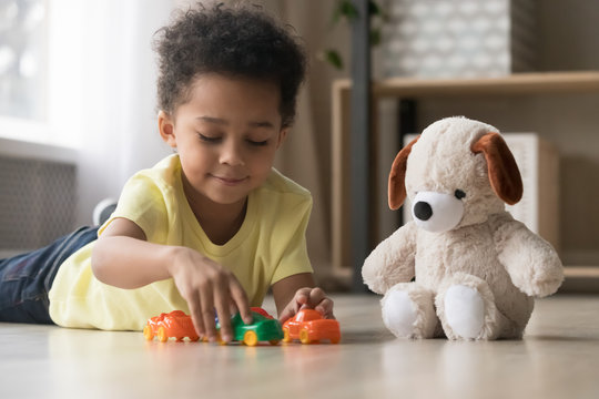 Adorable African Kid Lying On Warm Floor Play With Toys