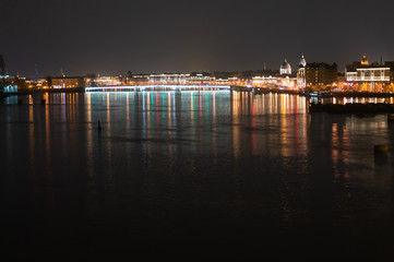 Night panoramic view of illuminated Neva River and Tuchkov Bridge, Saint Petersburg, Russia