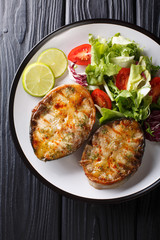 grilled sturgeon steaks with vegetable salad closeup on a plate. Vertical top view