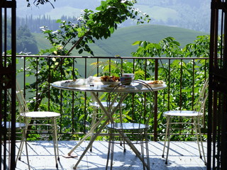 Breakfast on a patio in Tuscany Italy. Morning. Green fields in background.