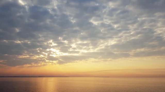 Colorful amazing dramatic sky with clouds at sunrise over river surface. Springtime. Video panorama, 4k